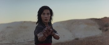 Movie still from “Mortal Kombat” (2021), directed by Simon McQuoid – A man in a black shirt and a red skirt; Medium shot, Low angle