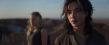 Movie still from “Mortal Kombat” (2021), directed by Simon McQuoid – A man and a woman standing next to each other in a field; Close Up shot, Over the shoulder angle