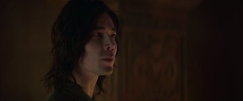 Movie still from “Mortal Kombat” (2021), directed by Simon McQuoid – A man with long black hair looking to his left; Close Up shot, Low angle