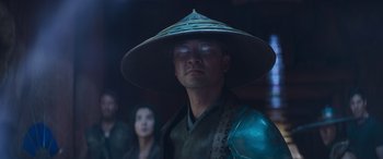 Movie still from “Mortal Kombat” (2021), directed by Simon McQuoid – A man wearing a hat and a green outfit; Close Up shot, Low angle