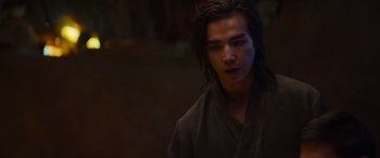 Movie still from “Mortal Kombat” (2021), directed by Simon McQuoid – A man with long black hair wearing a black robe; Close Up shot, Over the shoulder angle