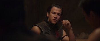 Movie still from “Mortal Kombat” (2021), directed by Simon McQuoid – A man in a leather vest holding a sword; Close Up shot, Low angle
