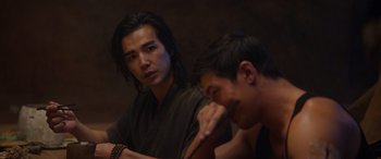 Movie still from “Mortal Kombat” (2021), directed by Simon McQuoid – Two asian men sitting at a table in front of a mirror; Close Up shot, Over the shoulder angle