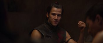 Movie still from “Mortal Kombat” (2021), directed by Simon McQuoid – A man in a black vest with a red dragon on it; Close Up shot, Over the shoulder angle