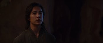 Movie still from “Mortal Kombat” (2021), directed by Simon McQuoid – A man with long black hair wearing a black robe; Close Up shot, Over the shoulder angle