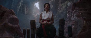 Movie still from “Mortal Kombat” (2021), directed by Simon McQuoid – A man sitting on top of a wooden post; Medium shot, Low angle
