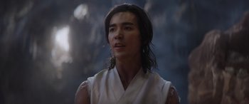 Movie still from “Mortal Kombat” (2021), directed by Simon McQuoid – A man with long black hair wearing a white shirt; Close Up shot, Over the shoulder angle