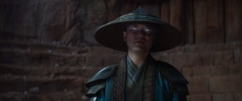 Movie still from “Mortal Kombat” (2021), directed by Simon McQuoid – A man wearing a hat and a costume; Close Up shot, Low angle