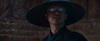 Movie still from “Mortal Kombat” (2021), directed by Simon McQuoid – A man wearing a hat with a light shining on it's face; Close Up shot, Low angle