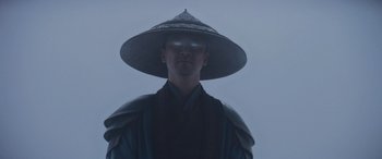Movie still from “Mortal Kombat” (2021), directed by Simon McQuoid – A man wearing a hat and a cape; Close Up shot, Low angle