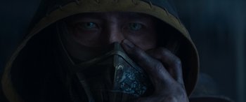 Movie still from “Mortal Kombat” (2021), directed by Simon McQuoid – A man wearing a mask and holding something to his face; Extreme Close Up shot, Low angle