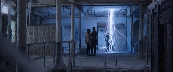 Movie still from “Mortal Kombat” (2021), directed by Simon McQuoid – Two people are standing in a room with lightning; Extreme Wide shot, Low angle