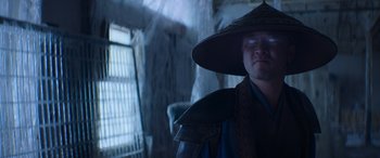 Movie still from “Mortal Kombat” (2021), directed by Simon McQuoid – A man wearing a hat and a cape; Close Up shot, Low angle