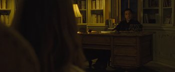 Movie still from “Mother!” (2017), directed by Darren Aronofsky – A room with a desk and a chair and bookcases; Medium shot, Over the shoulder angle