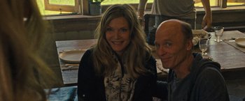 Movie still from “Mother!” (2017), directed by Darren Aronofsky – A man and a woman smiling for the camera; Medium shot, High angle