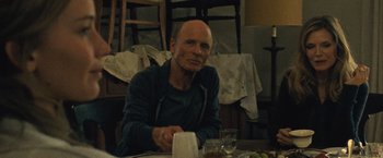 Movie still from “Mother!” (2017), directed by Darren Aronofsky – A man sitting at a table with a glass of wine; Medium shot, Over the shoulder angle