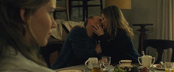 Movie still from “Mother!” (2017), directed by Darren Aronofsky – A man and a woman kissing at a dinner table; Medium shot, Over the shoulder angle