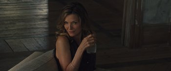 Movie still from “Mother!” (2017), directed by Darren Aronofsky – A woman holding a glass of water while sitting on a chair; Close Up shot, Over the shoulder angle