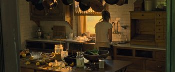 Movie still from “Mother!” (2017), directed by Darren Aronofsky – A woman standing in a kitchen next to a sink; Wide shot, High angle