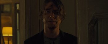 Movie still from “Mother!” (2017), directed by Darren Aronofsky – A young man with long brown hair is looking at the camera; Close Up shot, Over the shoulder angle