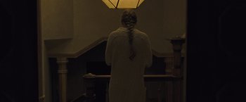 Movie still from “Mother!” (2017), directed by Darren Aronofsky – A woman standing in front of a railing with her hands on her head; Medium shot, Low angle