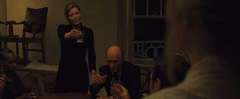Movie still from “Mother!” (2017), directed by Darren Aronofsky – A group of people sitting at a table with drinks; Medium shot, Over the shoulder angle