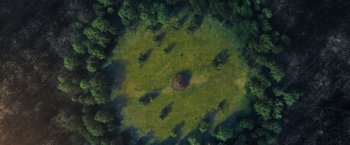 Movie still from “Mother!” (2017), directed by Darren Aronofsky – An aerial view of a field with trees in the background; Extreme Wide shot, Overhead angle