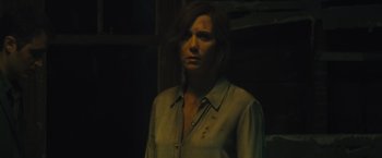 Movie still from “Mother!” (2017), directed by Darren Aronofsky – A woman in a green shirt is standing in a dark room; Close Up shot, Over the shoulder angle