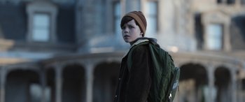 Movie still from “Mr. Harrigan's Phone” (2022), directed by John Lee Hancock – A young boy wearing a jacket and a hat; Medium shot, High angle