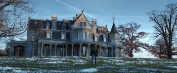 Movie still from “Mr. Harrigan's Phone” (2022), directed by John Lee Hancock – A man standing in front of a large old mansion; Extreme Wide shot, Low angle