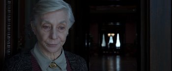 Movie still from “Mr. Harrigan's Phone” (2022), directed by John Lee Hancock – An older woman with white hair is smiling for the camera; Close Up shot, Over the shoulder angle