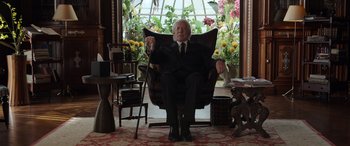 Movie still from “Mr. Harrigan's Phone” (2022), directed by John Lee Hancock – An older man sitting in a chair in a living room; Medium shot, Low angle
