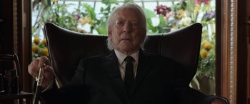 Movie still from “Mr. Harrigan's Phone” (2022), directed by John Lee Hancock – An older man in a suit and tie sitting in a chair; Close Up shot, Low angle