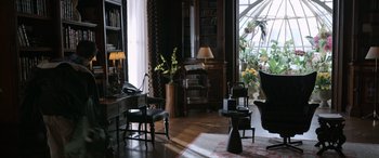 Movie still from “Mr. Harrigan's Phone” (2022), directed by John Lee Hancock – A living room filled with lots of furniture and potted plants; Wide shot, High angle