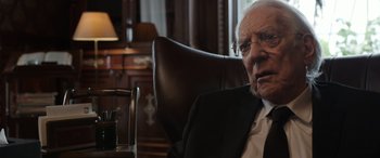 Movie still from “Mr. Harrigan's Phone” (2022), directed by John Lee Hancock – An older man in a suit sitting in a chair; Close Up shot, Over the shoulder angle