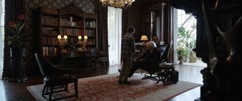 Movie still from “Mr. Harrigan's Phone” (2022), directed by John Lee Hancock – Two men are standing in a living room talking; Wide shot, Over the shoulder angle