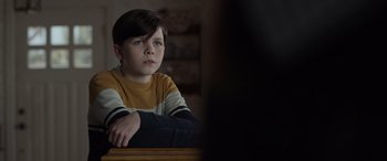 Movie still from “Mr. Harrigan's Phone” (2022), directed by John Lee Hancock – A young boy sitting in front of a television; Close Up shot, Over the shoulder angle