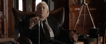 Movie still from “Mr. Harrigan's Phone” (2022), directed by John Lee Hancock – An older man in a suit and tie sitting in a chair; Close Up shot, Over the shoulder angle