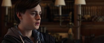 Movie still from “Mr. Harrigan's Phone” (2022), directed by John Lee Hancock – A young man is sitting in front of a lamp; Close Up shot, Over the shoulder angle