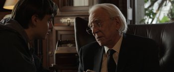 Movie still from “Mr. Harrigan's Phone” (2022), directed by John Lee Hancock – An older man wearing a suit and tie talking to a younger man; Close Up shot, Over the shoulder angle