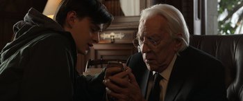 Movie still from “Mr. Harrigan's Phone” (2022), directed by John Lee Hancock – An older man and a young boy looking at a cell phone; Close Up shot, Over the shoulder angle