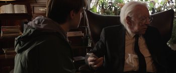 Movie still from “Mr. Harrigan's Phone” (2022), directed by John Lee Hancock – Two people sitting in a chair holding a wii controller; Close Up shot, Over the shoulder angle