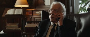 Movie still from “Mr. Harrigan's Phone” (2022), directed by John Lee Hancock – An older man in a suit and tie talking on a cell phone; Close Up shot, Over the shoulder angle