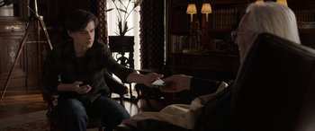 Movie still from “Mr. Harrigan's Phone” (2022), directed by John Lee Hancock – A man and a woman sitting in a living room; Medium shot, Over the shoulder angle