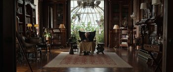 Movie still from “Mr. Harrigan's Phone” (2022), directed by John Lee Hancock – An older man sitting in a chair in front of a large window; Wide shot, Low angle