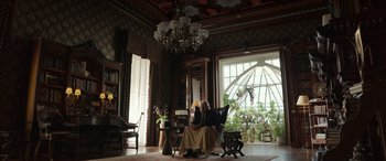 Movie still from “Mr. Harrigan's Phone” (2022), directed by John Lee Hancock – An older man sitting in a chair in a living room; Wide shot, Low angle