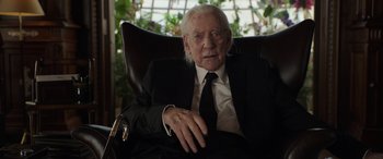 Movie still from “Mr. Harrigan's Phone” (2022), directed by John Lee Hancock – An older man in a suit and tie sitting in a chair; Close Up shot, Low angle