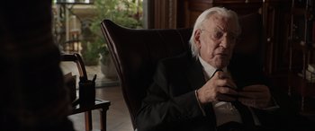 Movie still from “Mr. Harrigan's Phone” (2022), directed by John Lee Hancock – An older man sitting in a chair looking at his cell phone; Close Up shot, Over the shoulder angle