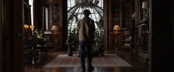 Movie still from “Mr. Harrigan's Phone” (2022), directed by John Lee Hancock – A man standing in front of a window in a room; Wide shot, Low angle