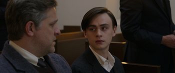 Movie still from “Mr. Harrigan's Phone” (2022), directed by John Lee Hancock – A young man with long hair and a suit jacket on; Close Up shot, Over the shoulder angle